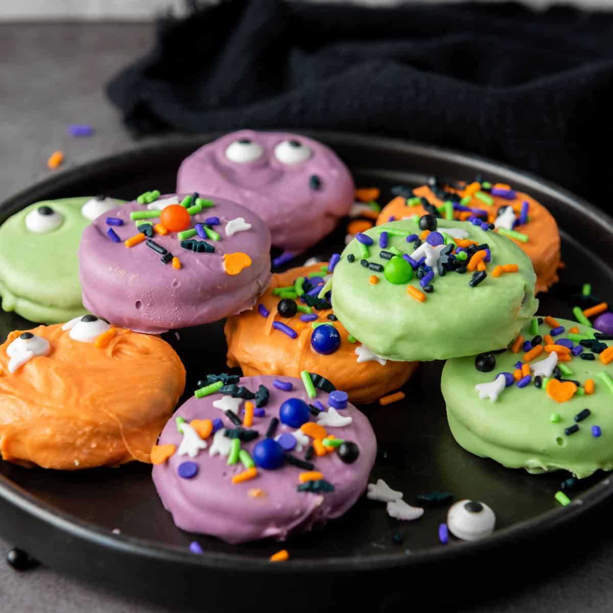 Oreo cookies decorated with white and black icing to look like jack-o-lanterns and ghosts.