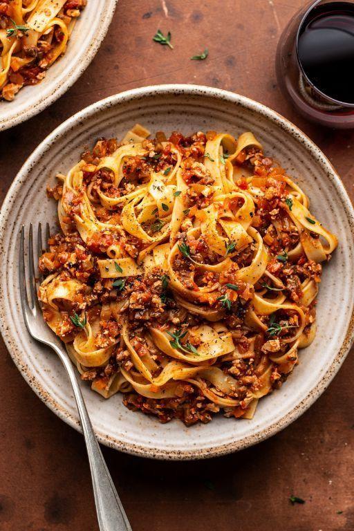 Vegan mushroom bolognese captures beef bolognese flavor, topped with parmesan, fresh basil, tomato sauce, pasta