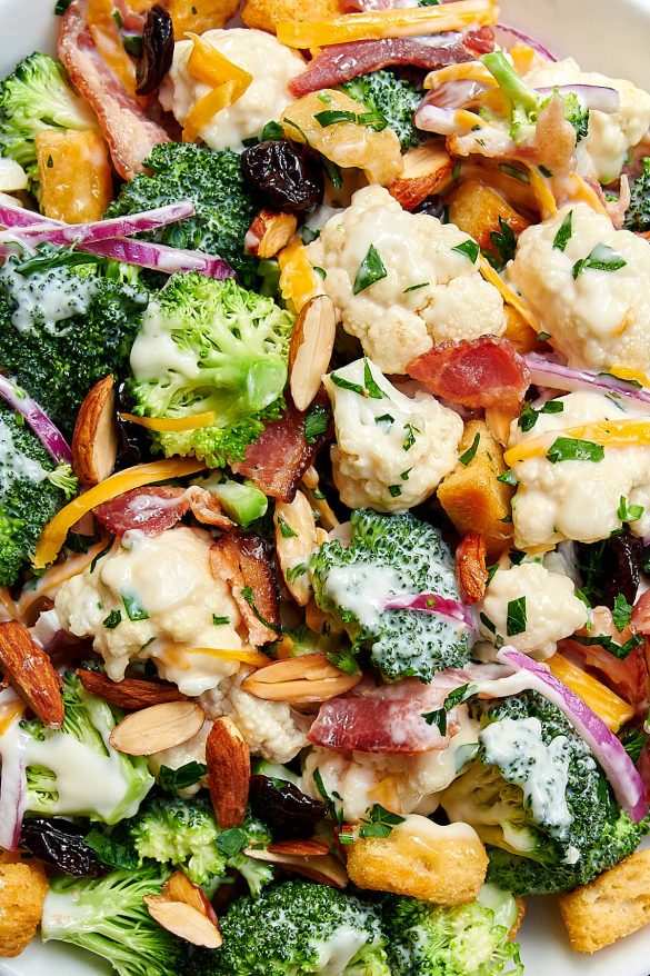 Broccoli cauliflower salad with florets, herbed yogurt dressing, toasted pine nuts, dried currants, and feta crumbles
