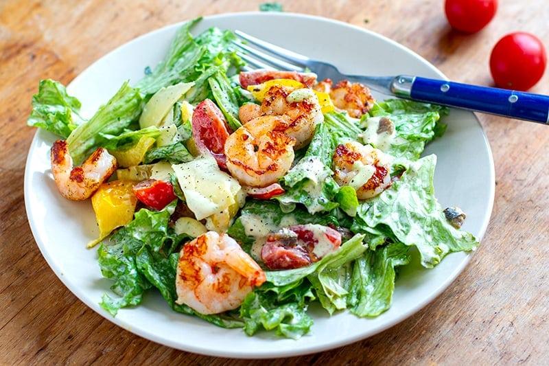 Lemon pepper shrimp caesar salad with bright grilled seafood crisp romaine and creamy dressing