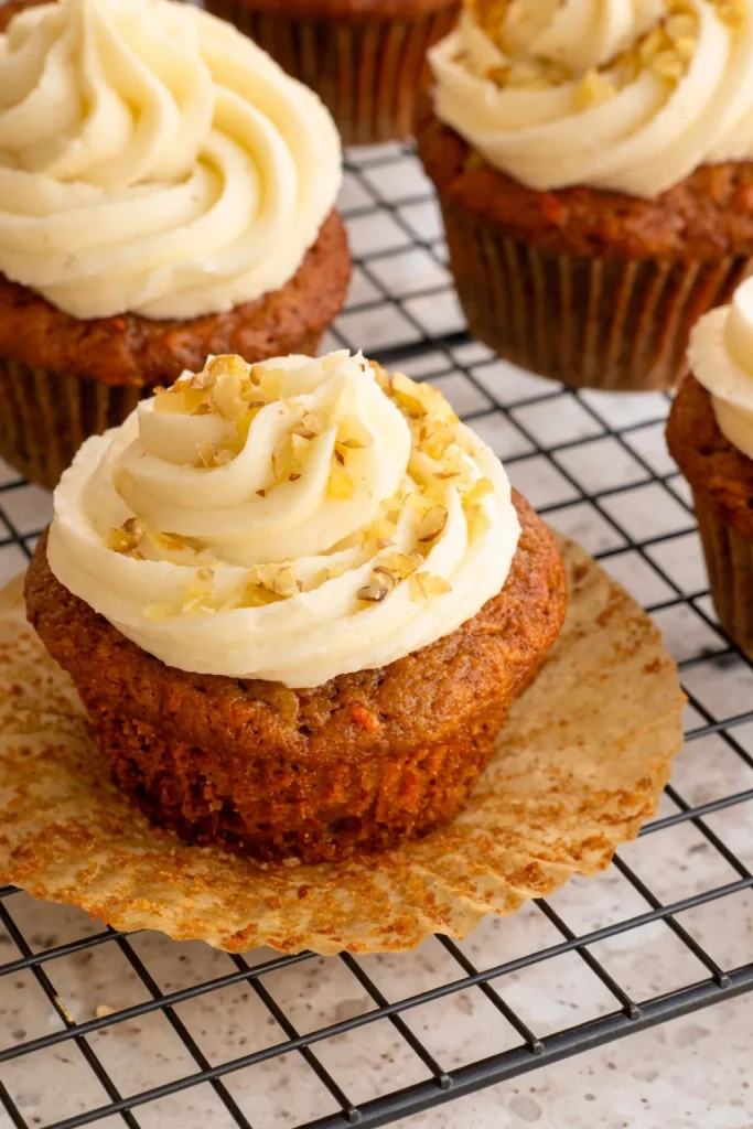 Moist carrot cupcake studded with pineapple chunks, topped with spiced cream cheese frosting and toasted coconut