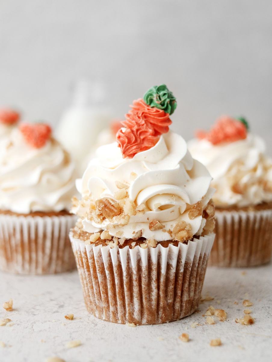 Fluffy vegan carrot cupcakes with maple‑sweetened cream cheese frosting and toasted walnuts