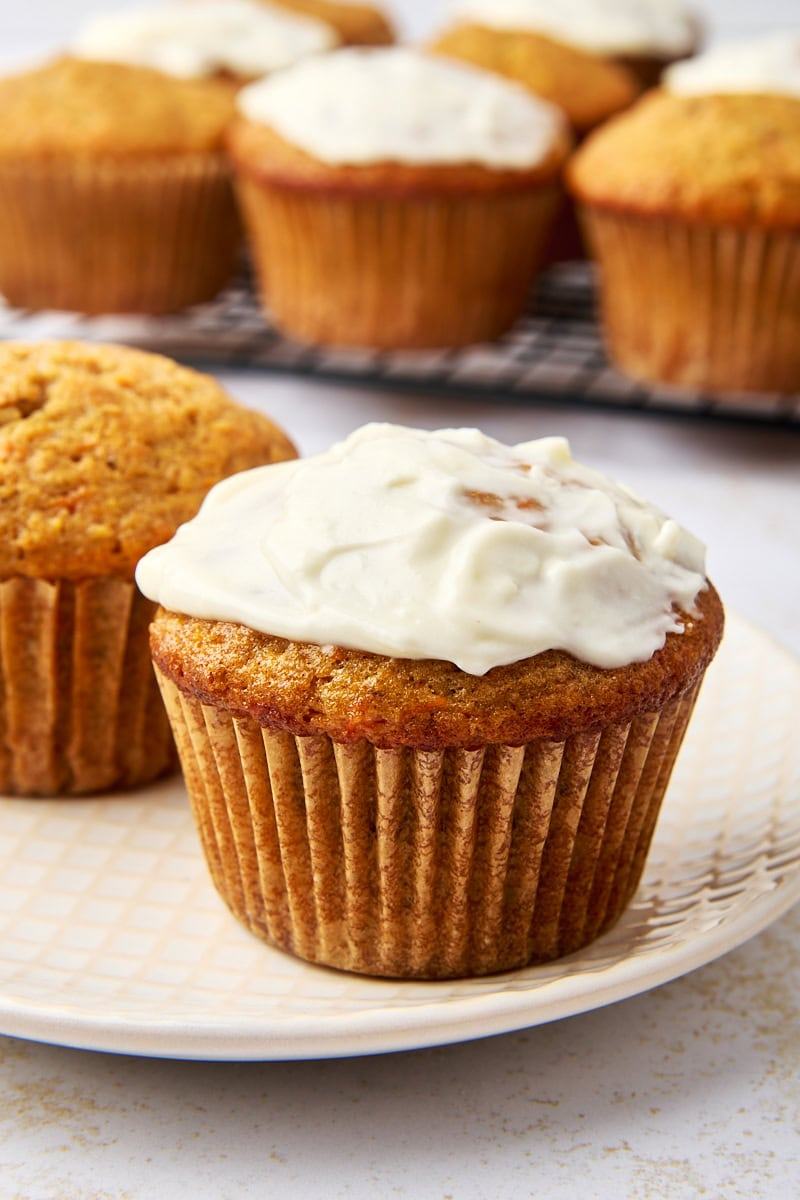 Homemade carrot cupcake topped with smooth cream cheese frosting, moist spiced carrot crumb, and subtle nutty notes