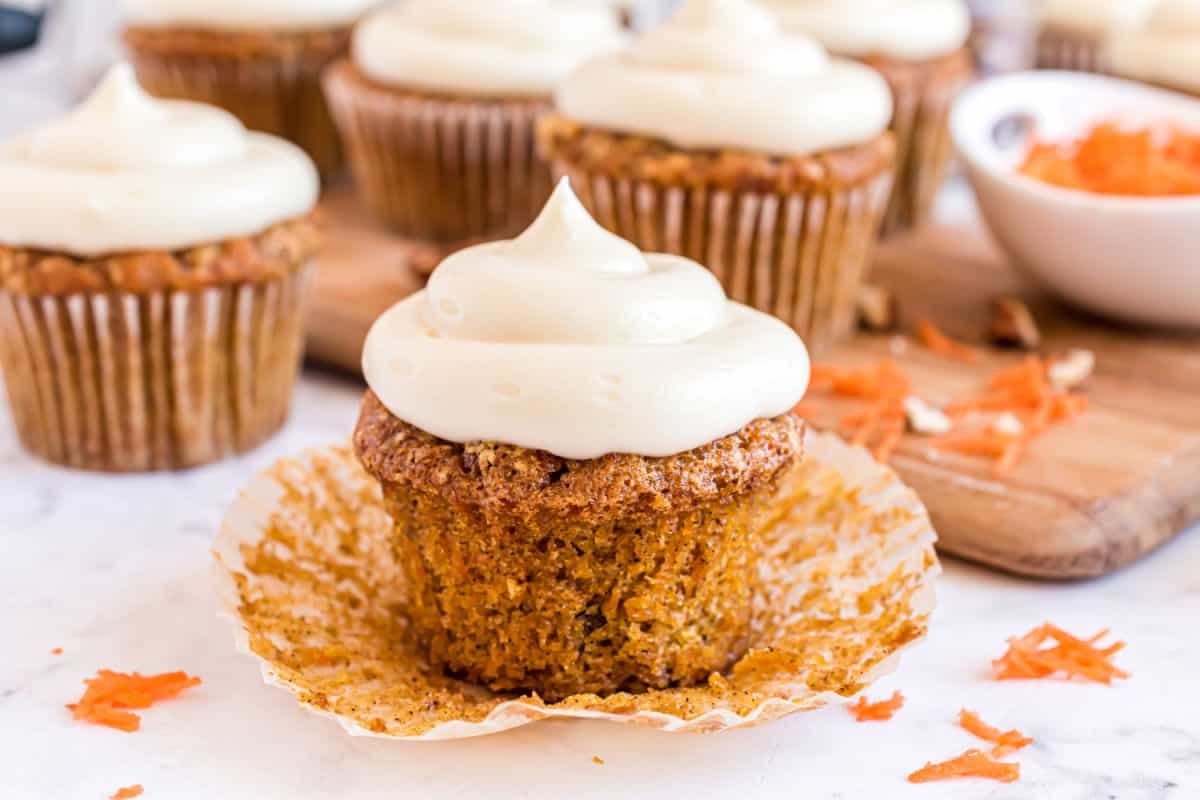 Carrot cupcake topped with nutty cream cheese frosting and a sprinkle of toasted almond slivers