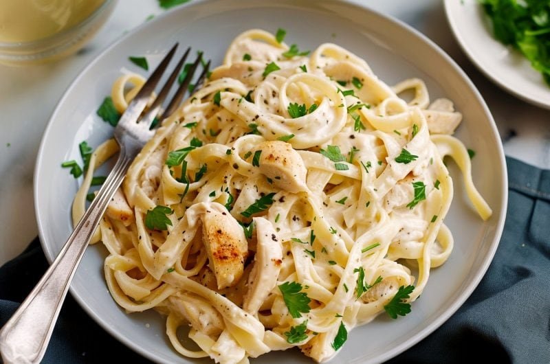 Classic fettuccine chicken alfredo with tender chicken and silky parmesan cream sauce on pasta.