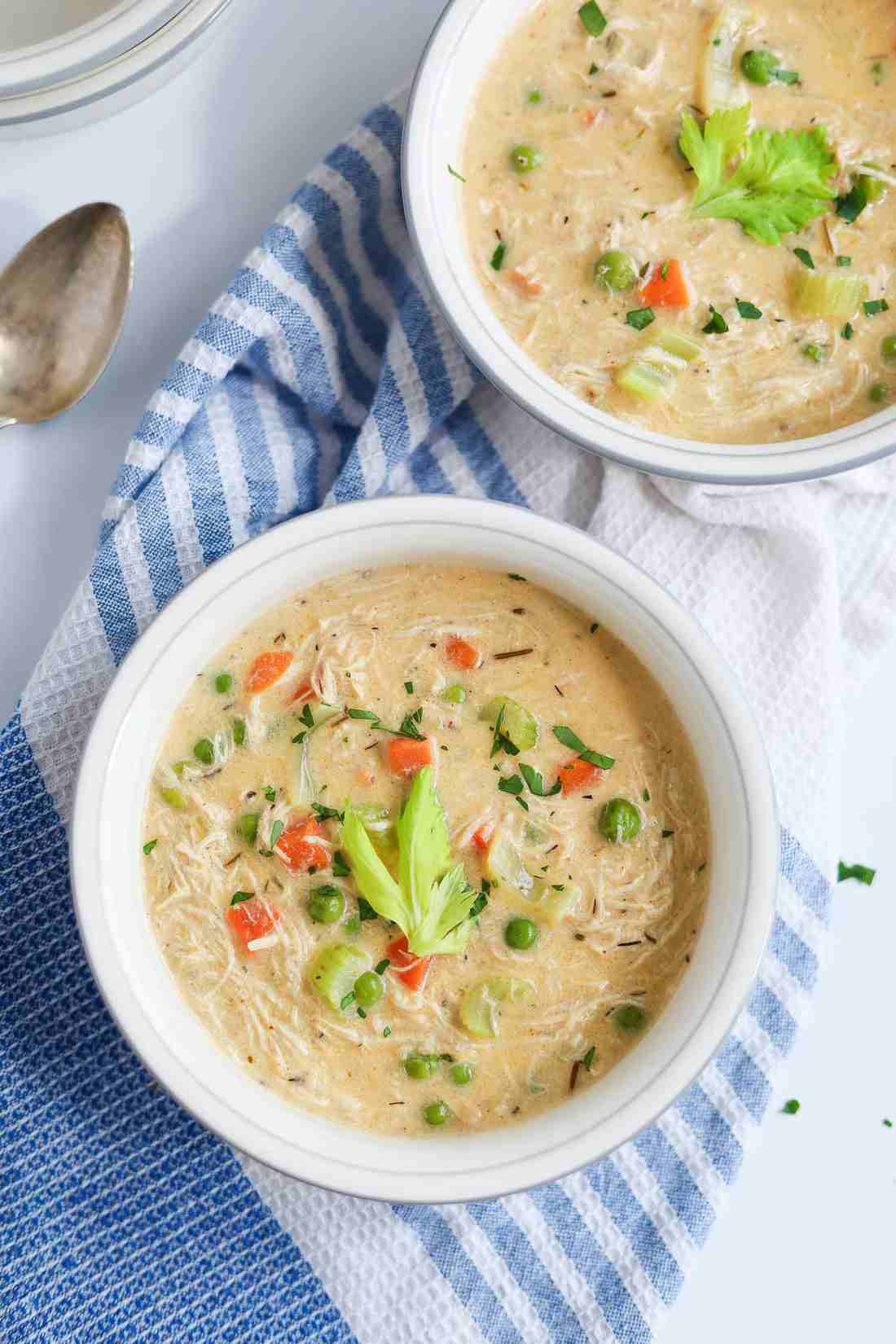 Instant Pot chicken pot pie soup with creamy broth, tender chicken, carrots, peas, potatoes, and a flaky pastry crust topping