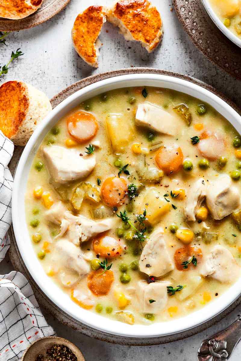 Creamy chicken pot pie soup with buttery cornbread topping, chicken, peas, carrots, potatoes