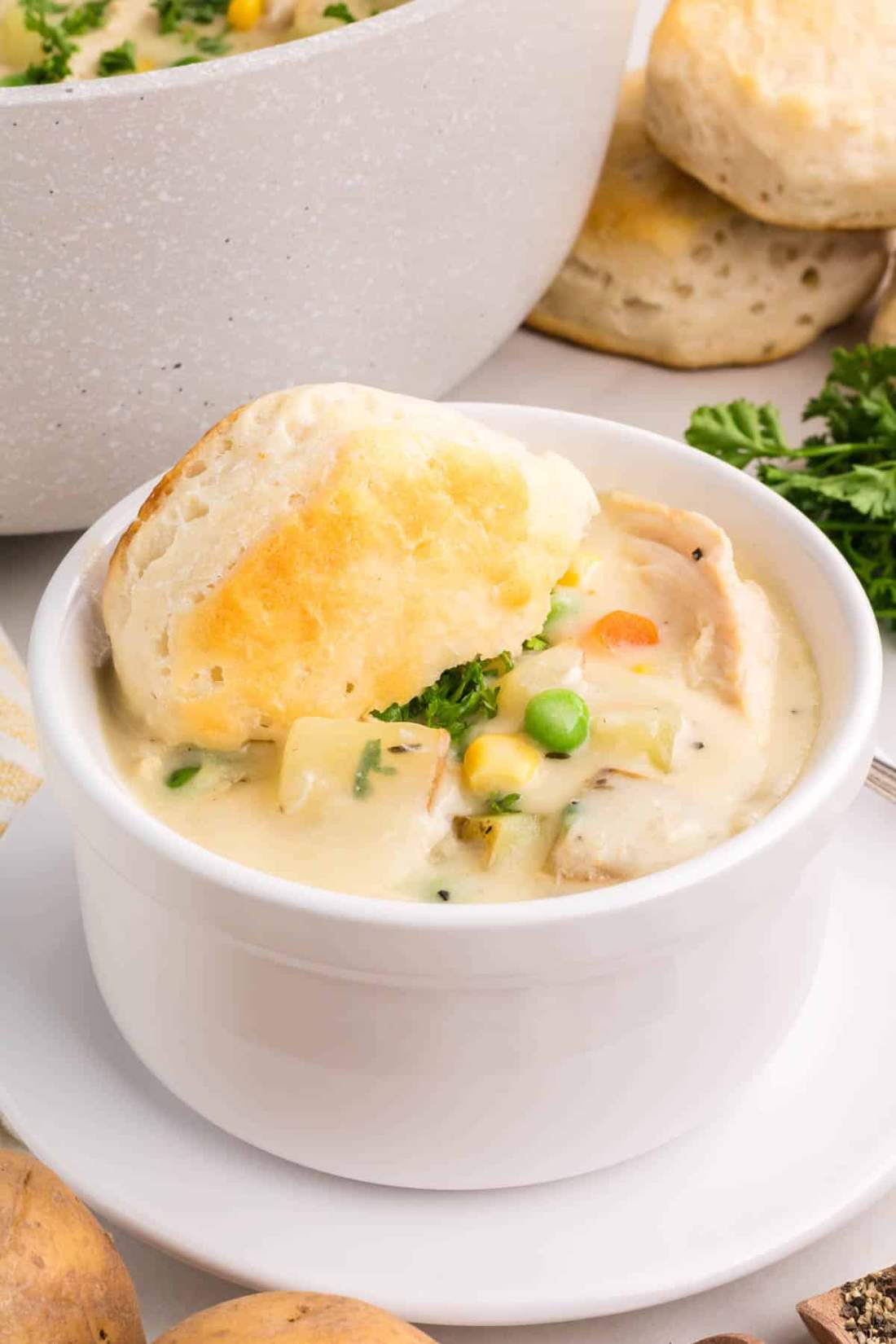 Creamy chicken pot pie soup with garlic‑herb biscuits, tender chicken, peas, carrots, potatoes