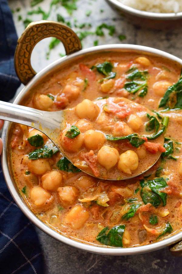 Creamy coconut chickpea curry with a golden sauce, fresh cilantro, and lime, served over fluffy rice.