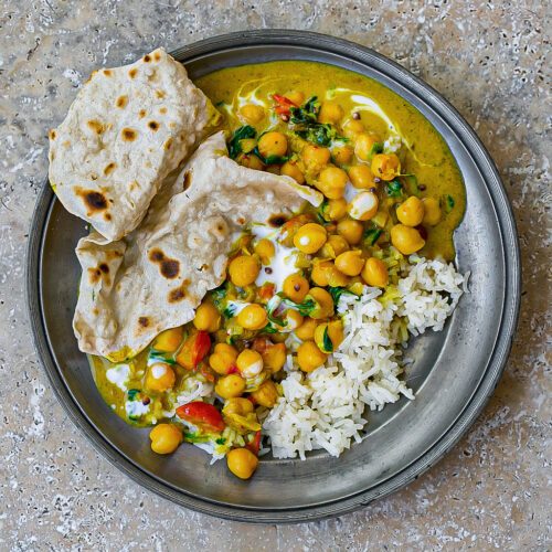 Coconut chickpea curry with golden turmeric, spices, cilantro, served with basmati rice