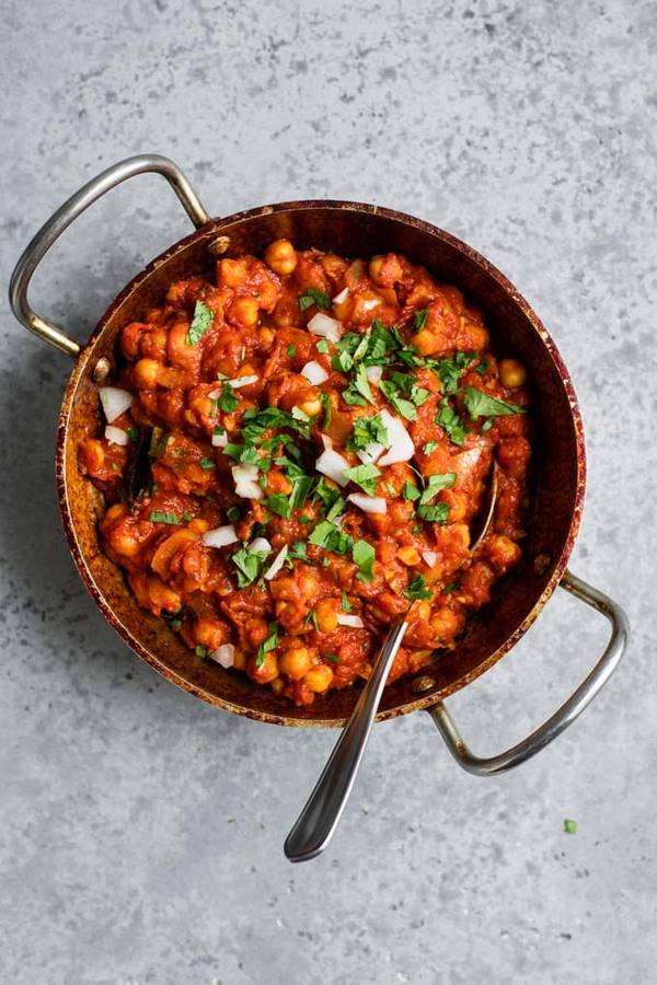 Authentic dhaba style classic chana masala, tender chickpeas, dark spiced curry sauce, fresh cilantro, rice.