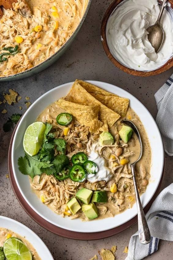 Creamy white chicken chili in a bowl topped with shredded Monterey Jack and sliced jalapeños