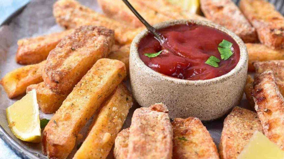 Golden tofu sticks dusted with seasoning, served with a creamy sriracha dip on a festive tray
