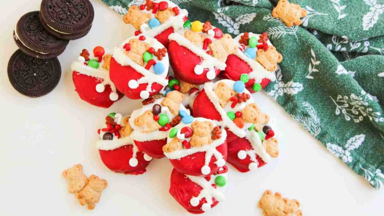 Red‑and‑green dipped Oreo cookies shaped like Santa sacks, sprinkled with festive sugar crystals