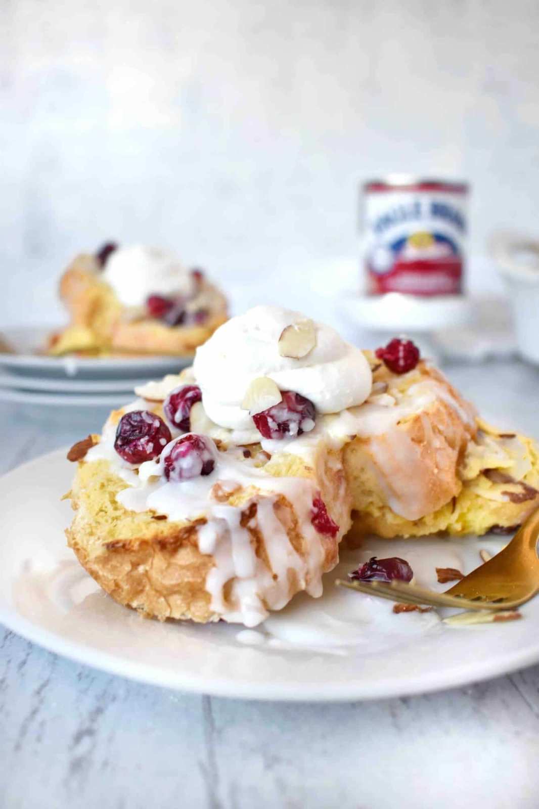 Golden scones dotted with dried cranberries and sliced almonds, drizzled with glossy vanilla glaze