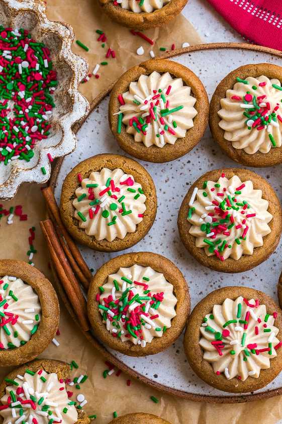 Small gingerbread cups filled with spiced buttercream frosting on a festive plate.