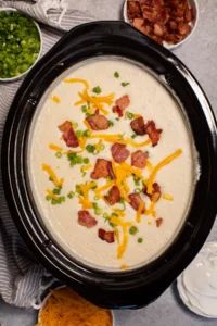 Creamy potato soup topped with shredded cheddar, crispy bacon, and green onions