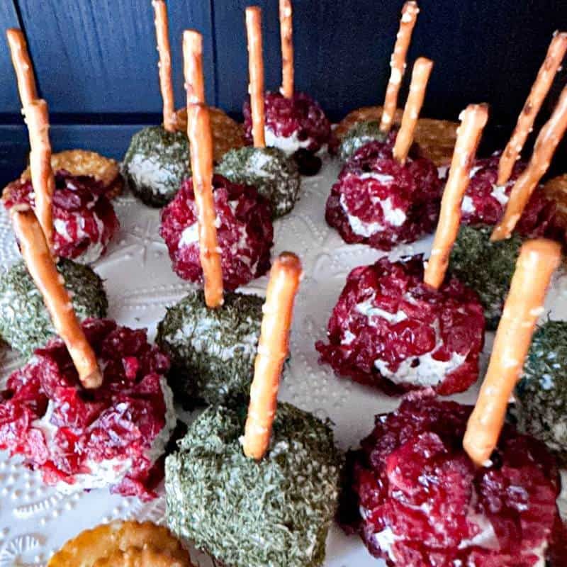 Tiny cheese balls flavored with cranberry and dill perched on pretzel sticks