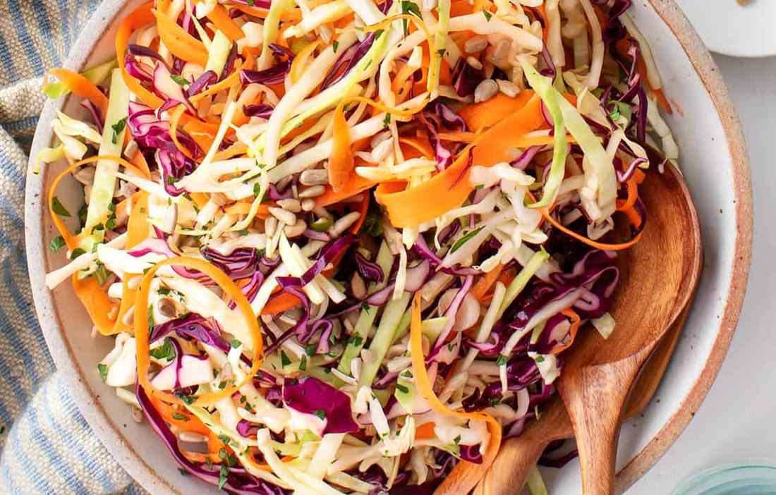 Classic vinegar coleslaw with crisp cabbage, bright tang, and a light creamy drizzle