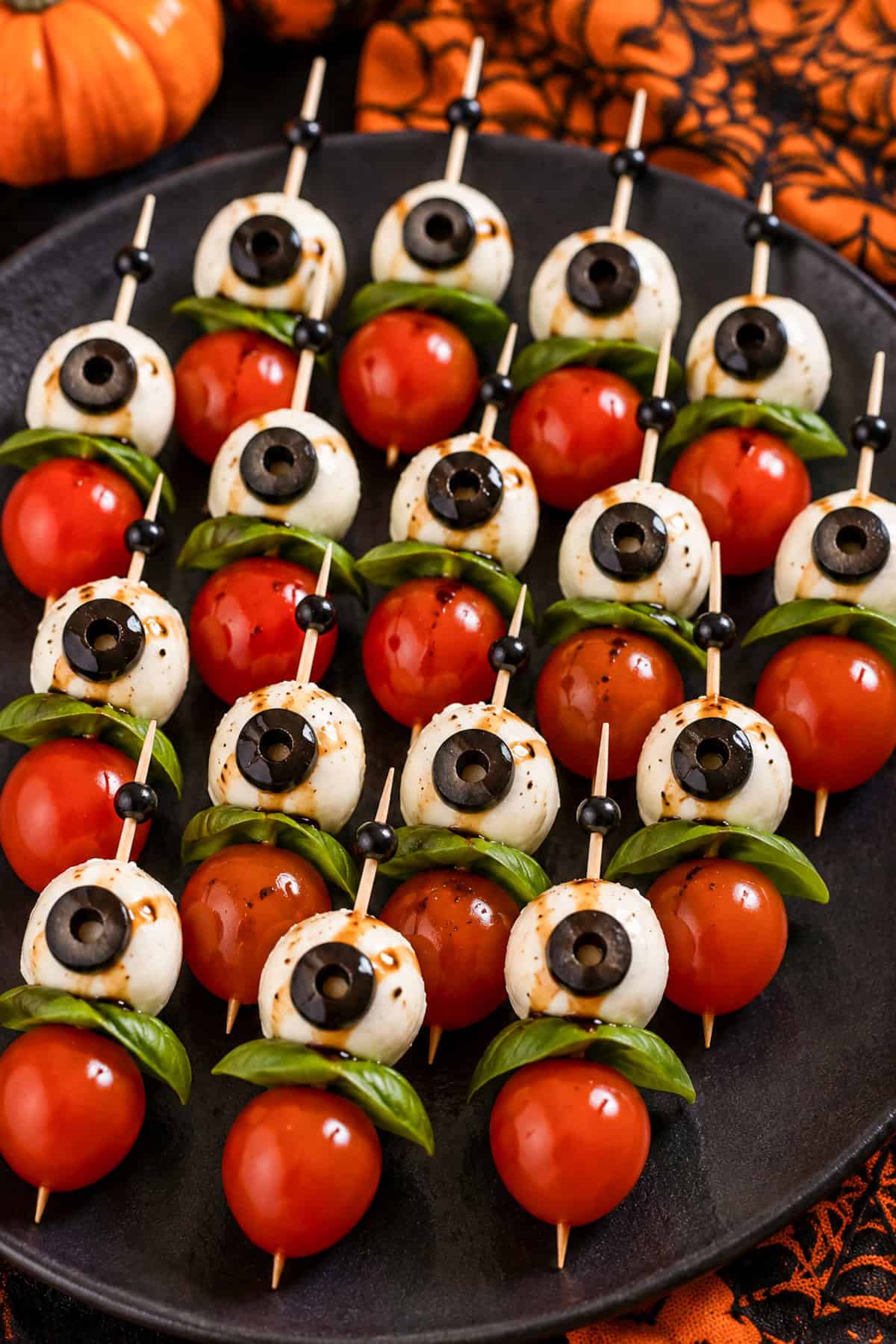 Cherry tomatoes skewered with mozzarella balls and black olive slices to resemble human eyeballs.