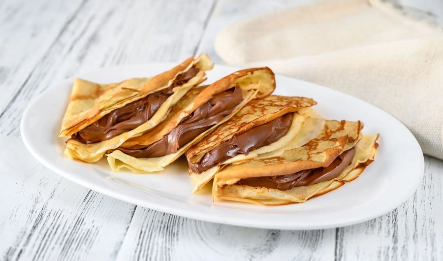 Thin golden crepes filled with silky Nutella, topped with chocolate drizzle and whipped cream