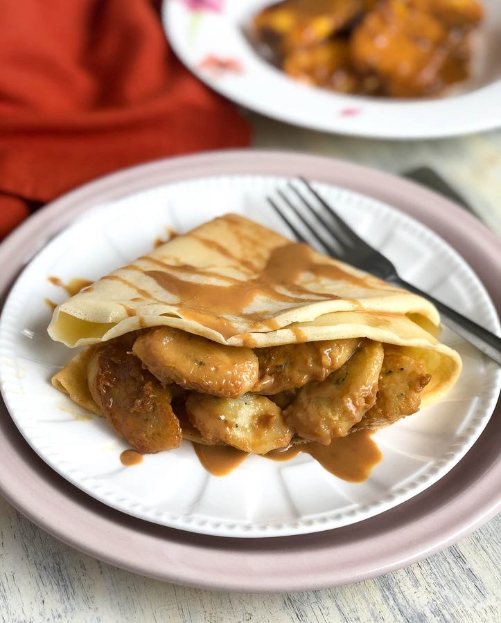 Thin golden crepes filled with sliced bananas and a silky caramel sauce, topped with toasted nuts