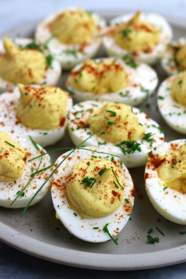 Creamy yolk filling with paprika, chives, and bacon bits on hard-boiled eggs