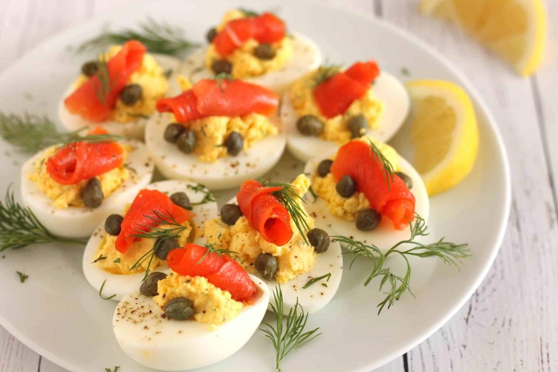 Deviled eggs filled with crab meat, avocado, lime, and a pinch of paprika