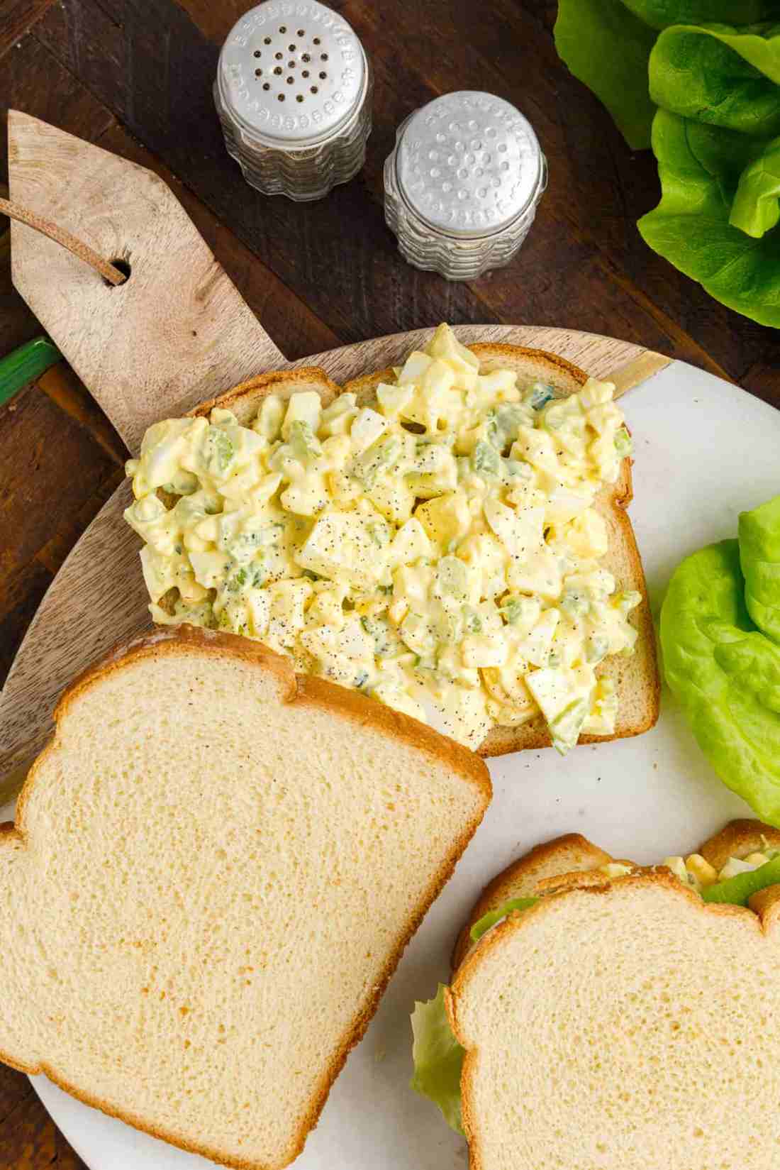 Fresh egg salad sandwich with chopped hard-boiled eggs, creamy mayo, crisp lettuce, and herbs