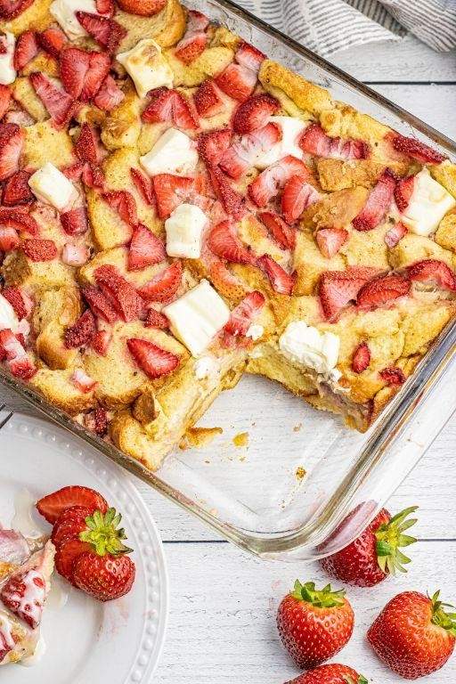 Strawberry jam French toast casserole with golden custardy bread cubes, warm strawberry glaze, and a touch of maple syrup