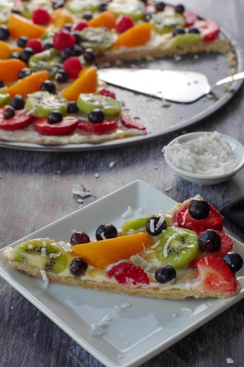 Sugar cookie crust with cream cheese frosting, sliced apples, caramel drizzle, and a sprinkle of cinnamon, autumn fruit pizza