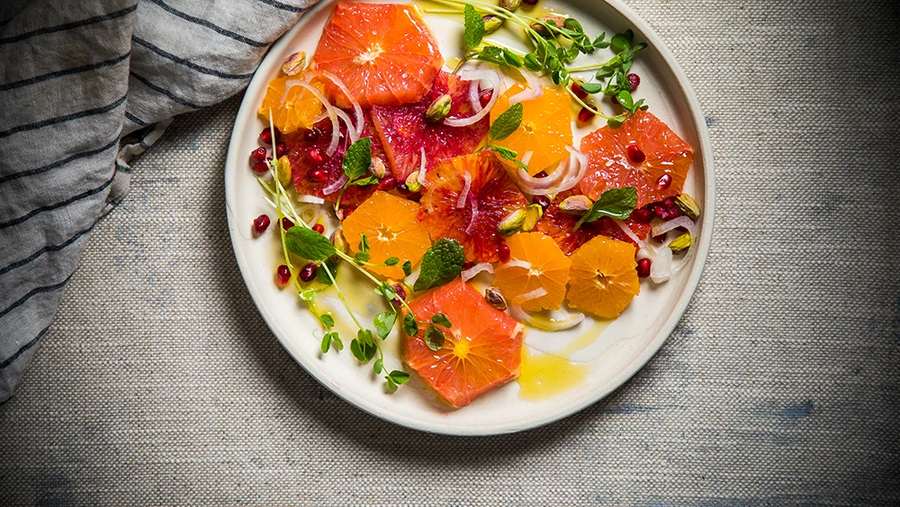 Tropical honey citrus fruit salad featuring pineapple, kiwi, citrus segments, and a honey glaze