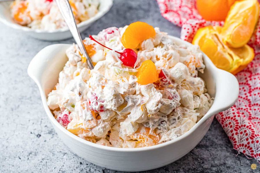 Creamy ambrosia fruit salad with Greek yogurt, berries, kiwi, and pistachios