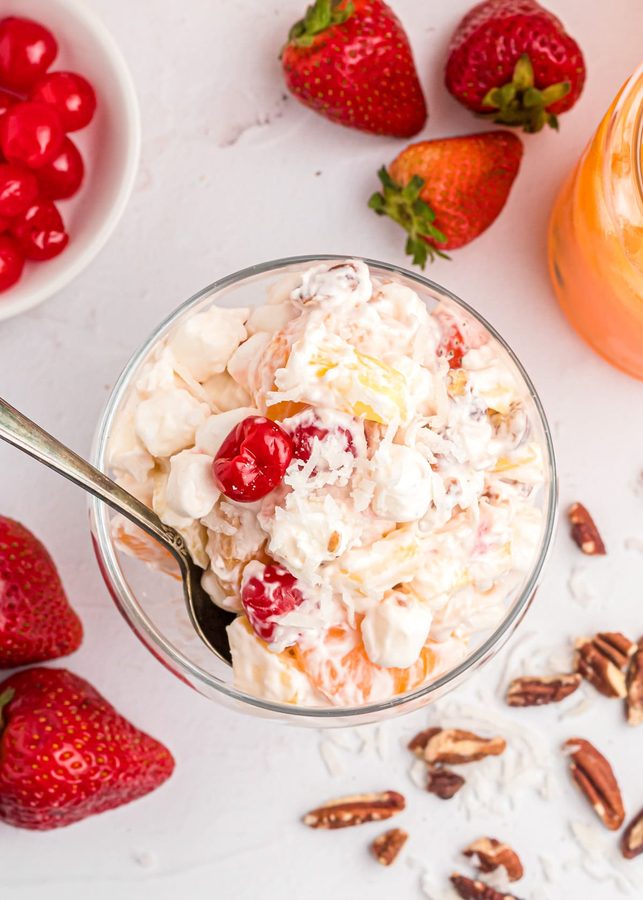 Creamy ambrosia fruit salad with mascarpone, berries, peach, and pistachios