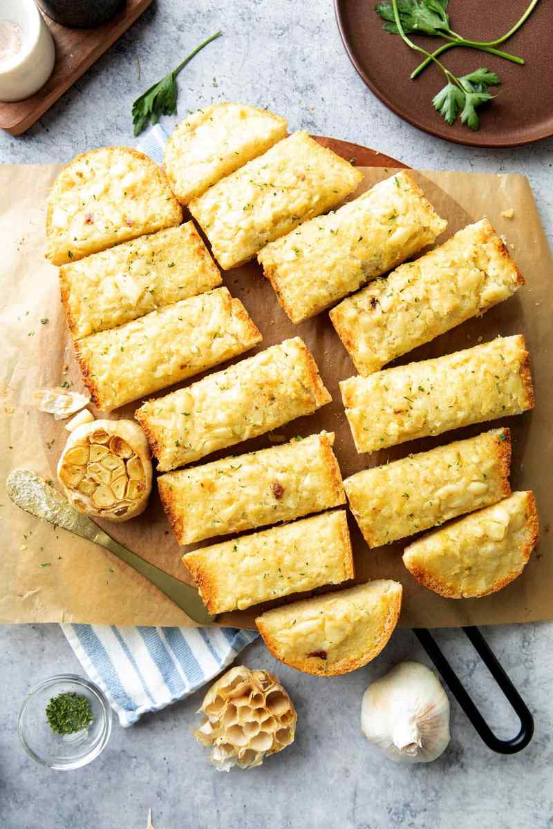 Roasted garlic bread topped with melted cheese and herb blend, golden crust, aromatic garlic