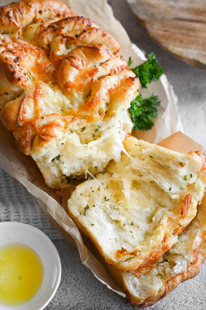 Triple‑cheese garlic bread with herb‑infused butter, golden crust, and melted cheese