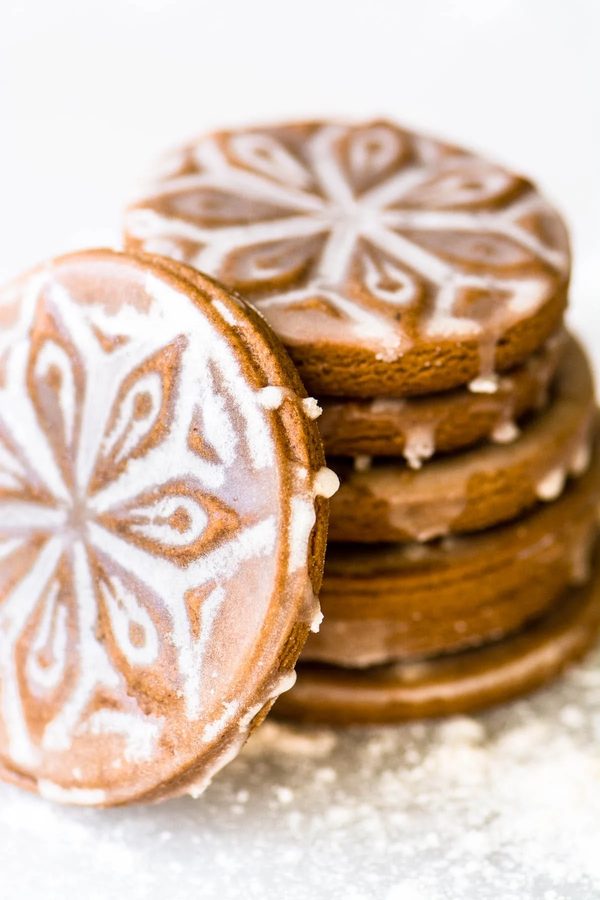 Stencil-patterned snowflake gingerbread rounds, warm spices, festive design, holiday charm