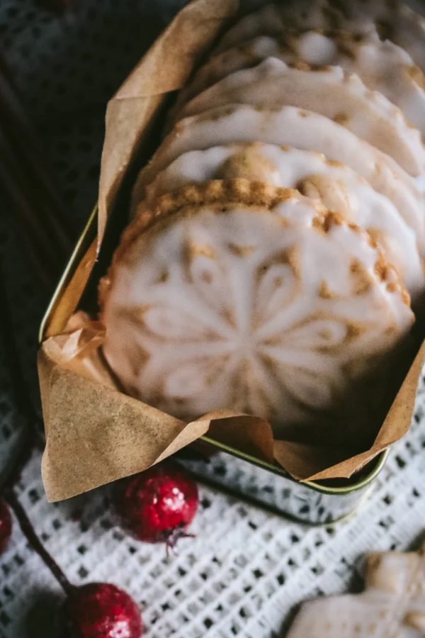 Round gingerbread medallion cookies glazed with shiny icing, placed in a festive gift box