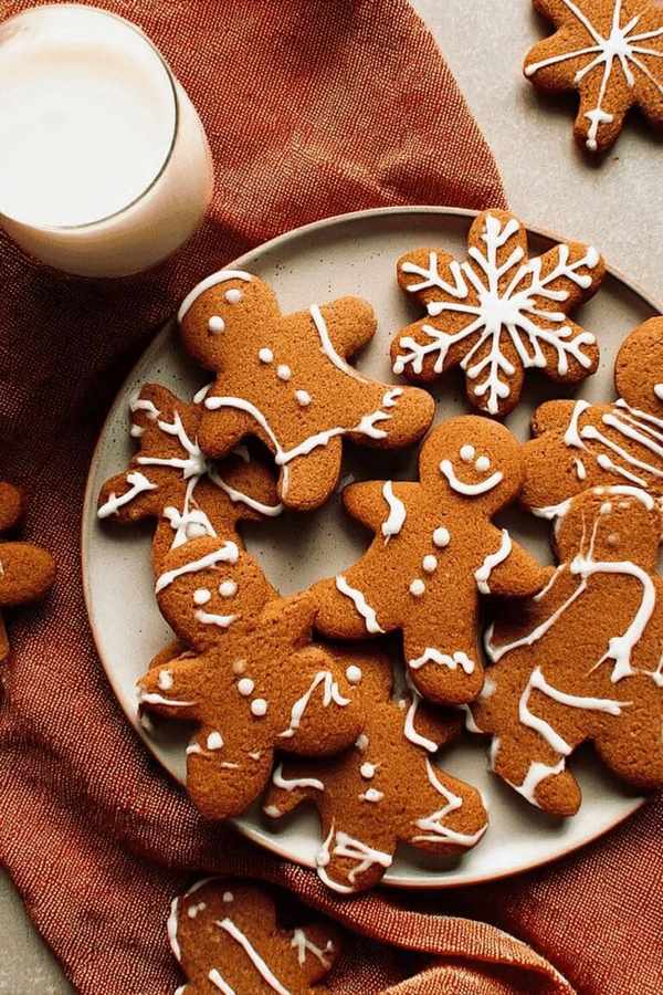 Iced gingerbread men and stars served with a glass of cold milk, warm spices, festive icing