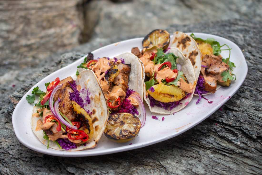 Grilled pineapple tacos with crisp broccoli florets, zesty dressing, toasted nuts, dried fruit, cheese