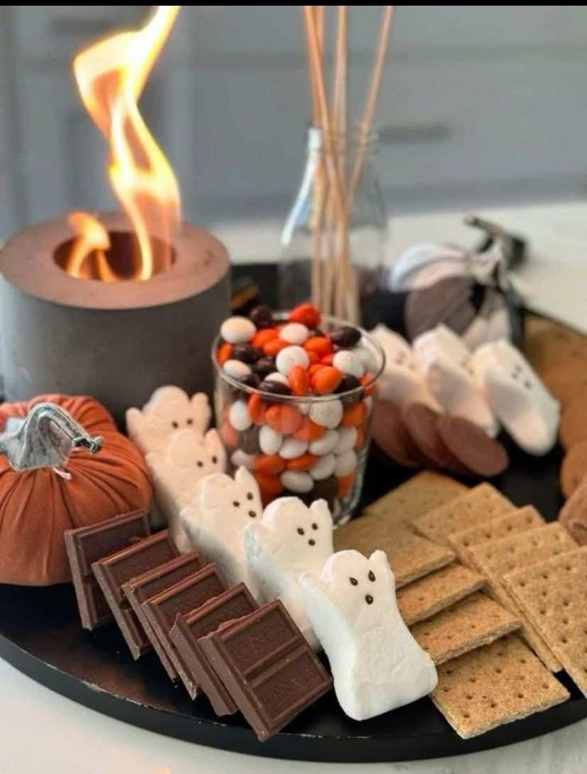 Ghost-shaped graham crackers with white chocolate and marshmallow on a wooden board