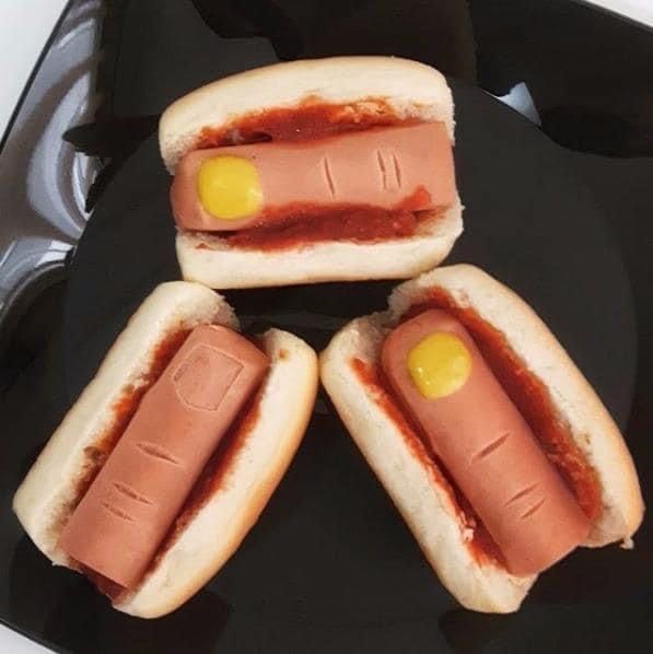 Hot dogs in buns with ketchup nails and mustard veins looking like severed fingers
