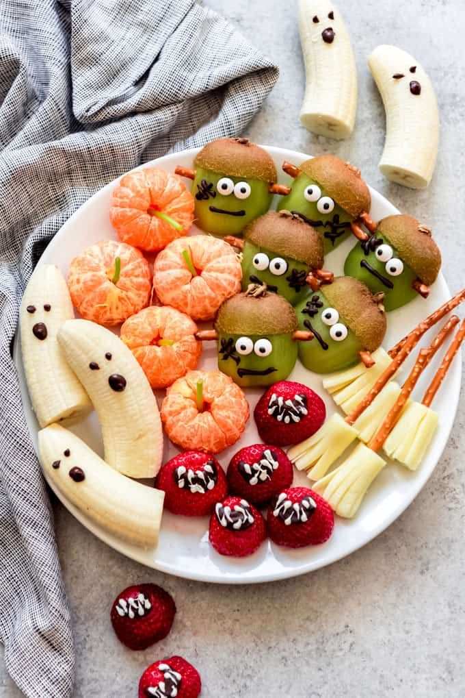 A fruit platter arranged to look like Frankenstein's monster with green grapes and kiwi.