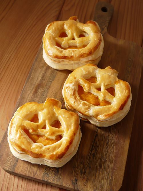 Puff pastry pies filled with pumpkin custard and shaped like jack-o-lanterns