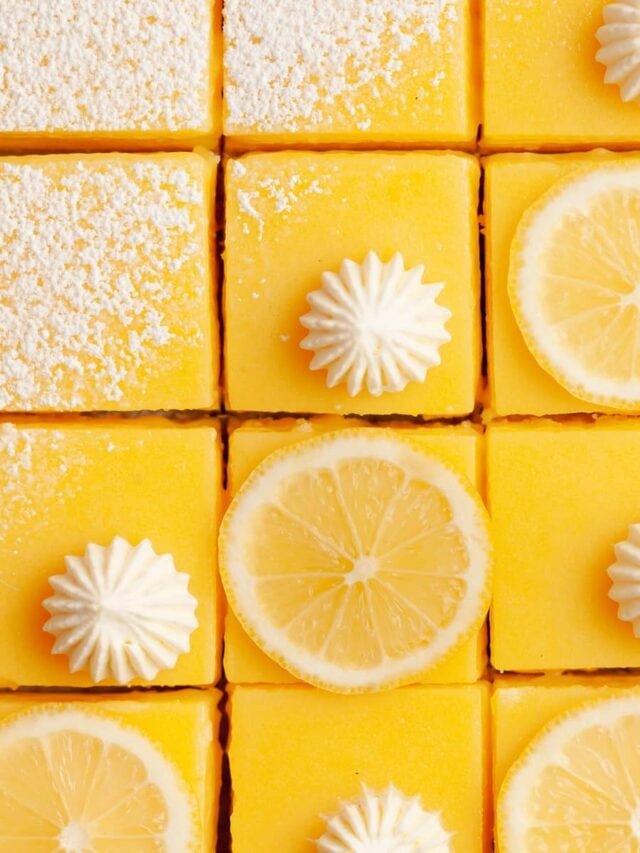 Golden coconut‑almond crust lemon bars dusted with powdered sugar, bright yellow filling