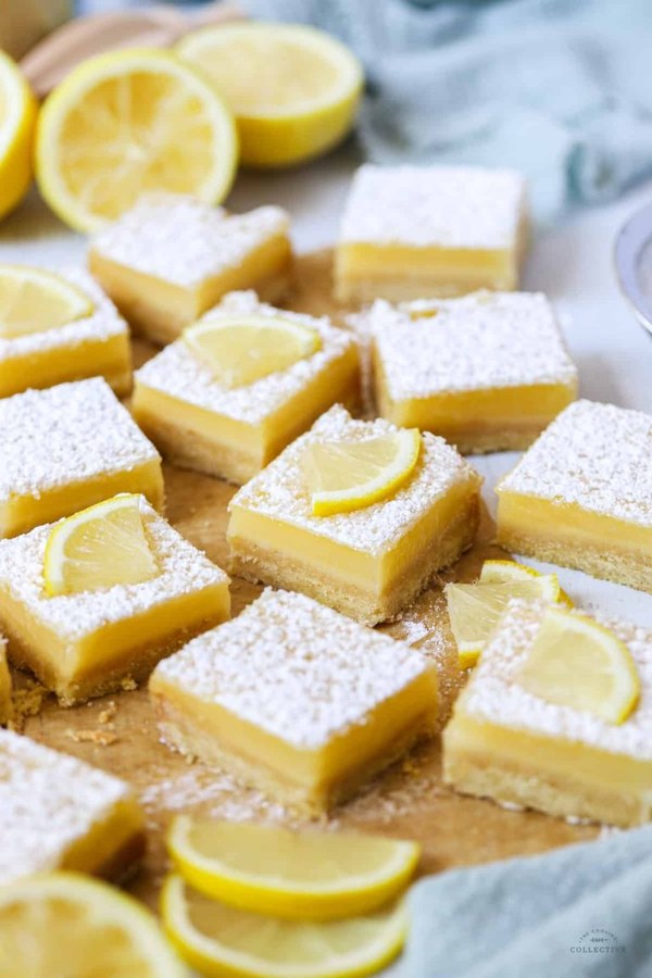 Golden lemon curd slice bars topped with whipped cream and fresh berries