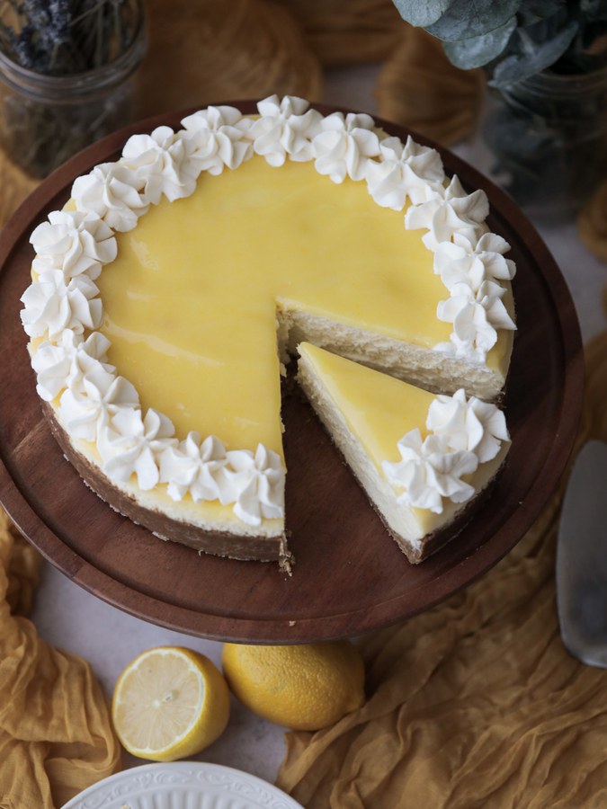 Creamy lemon curd cheesecake on a buttery graham crust, topped with fresh berries