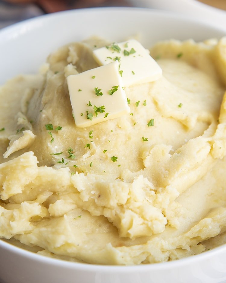 Slow cooker mashed potatoes blended with tangy sour cream, melted butter, and fresh green chives