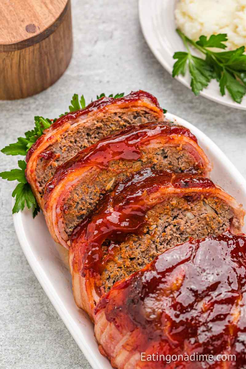 Sweet and smoky bacon-wrapped meatloaf with caramelized glaze, tender beef center