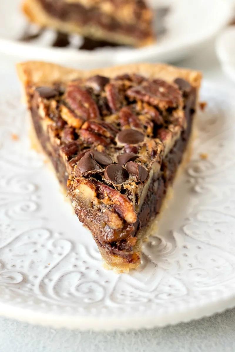 Rich chocolate pecan pie slice with glossy fudge filling and roasted nuts